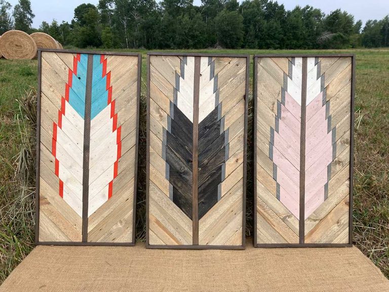Three rectangular signs made out of slats of wood create a feather design